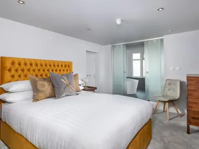 a bedroom with a large bed and a chair at Apartment 3 Helvellyn in Keswick