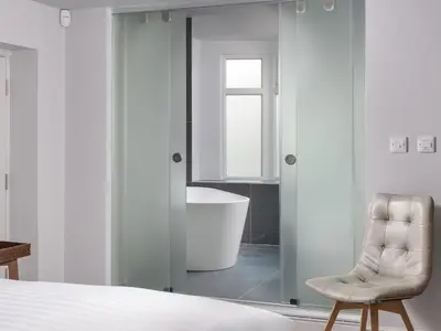 a bedroom with a bath tub and a chair at Apartment 3 Helvellyn in Keswick