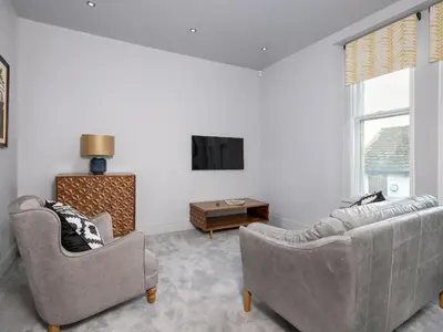 a living room with two couches and a tv at Apartment 4 Skiddaw in Keswick