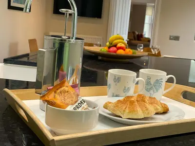 a tray with a plate of food and coffee cups at Wordsworth House HOT TUB HIRE AVAILABLE in Keswick