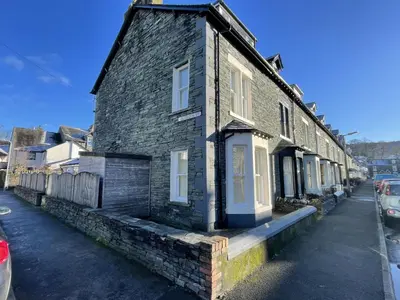 an old stone house on the side of a street at Wordsworth House HOT TUB HIRE AVAILABLE in Keswick