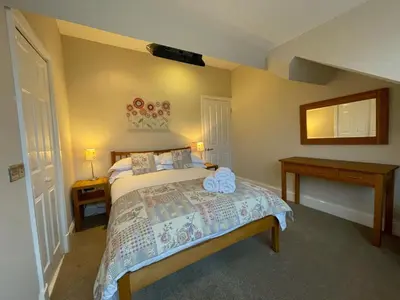 a bedroom with a bed and two tables and a mirror at Wordsworth House HOT TUB HIRE AVAILABLE in Keswick