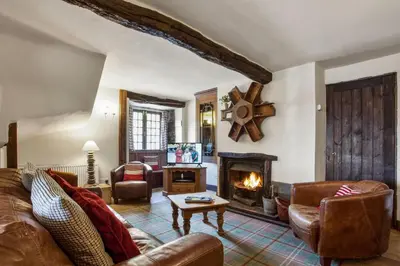 a living room with a couch and a fireplace at The Mountain Cottages - Carpenters in Coniston