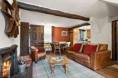 a living room with a couch and a fireplace at The Mountain Cottages - Carpenters in Coniston