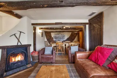a living room with a couch and a fireplace at The Mountain Cottages - Sawyers in Coniston