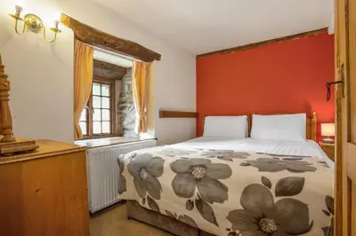 a bedroom with a bed and a window at The Mountain Cottages - Millrace in Coniston