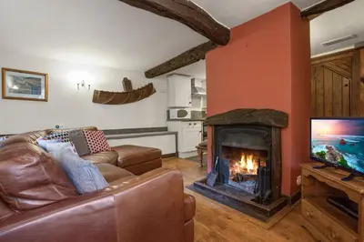 a living room with a couch and a fireplace at The Mountain Cottages - Millrace in Coniston