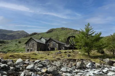 an old house on a hill in the mountains at The Mountain Cottages - Millrace in Coniston