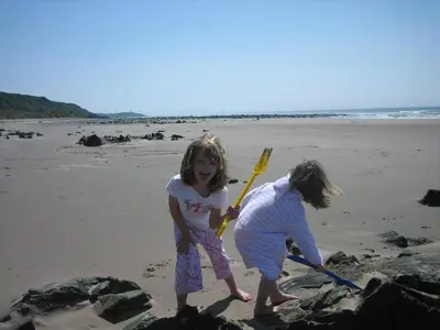 two little girls playing in the sand on the beach at Stables Cottage in Stranraer