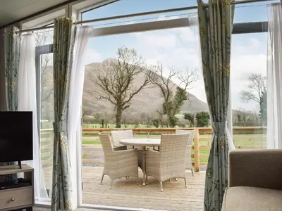a patio with a table and chairs in front of a window at Dodd - Uk42499 in Bassenthwaite