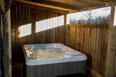 a jacuzzi tub in a wooden building at Bird House - Sleep with the Owls! in Carlisle