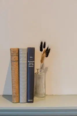 three books and a vase on a shelf at The Old Mill Inn in Dearham