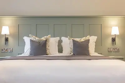 a large bed with white pillows and pillows at The Old Mill Inn in Dearham