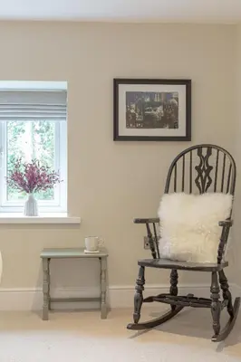 a chair with a pillow and a table in a room at The Old Mill Inn in Dearham