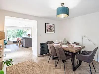 a dining room and living room with a table and chairs at Northdene - 5 star Lake District Cottage in Cockermouth