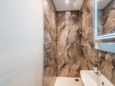 a bathroom with a sink and a toilet and a shower at Northdene - 5 star Lake District Cottage in Cockermouth