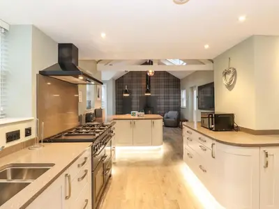 a large kitchen with white cabinets and a stove at Blencathra in Keswick
