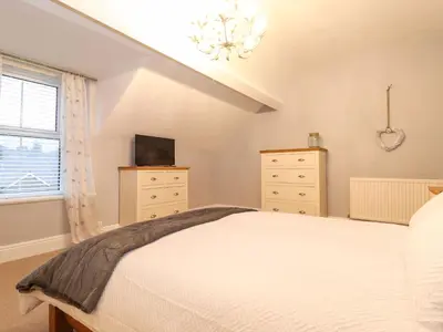 a bedroom with a bed and a tv and a window at Blencathra in Keswick