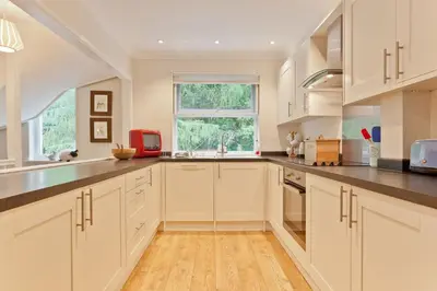 a kitchen with white cabinets and a window at Herdwick Place Langdale Valley in Great Langdale
