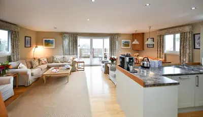 a kitchen and living room with a couch and a table at Cedar Lodge in Portpatrick