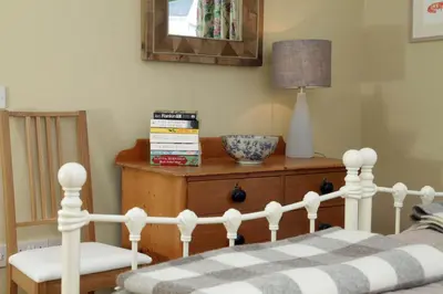 a bedroom with a bed and a table with a lamp at Cedar Lodge in Portpatrick