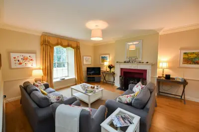 a living room with two couches and a fireplace at Garden Cottage in Stranraer