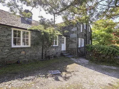 an old stone house with a white door at St Giles in Ambleside