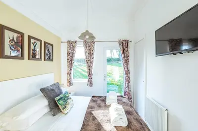 a bedroom with a bed and a window at Squirrel Lodge 41 with Hot Tub in Newton Stewart