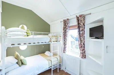 a bedroom with two bunk beds and a tv at Squirrel Lodge 42 with Hot Tub in Newton Stewart