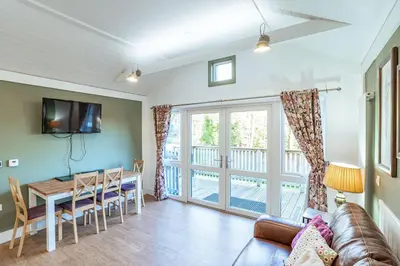 a living room with a couch and a table at Squirrel Lodge 42 with Hot Tub in Newton Stewart