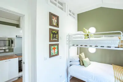 a bedroom with a bunk bed and a kitchen at Squirrel Lodge 42 with Hot Tub in Newton Stewart