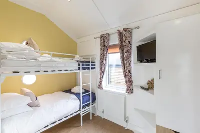 two bunk beds in a small room with a window at Squirrel Lodge 43 with Hot Tub in Newton Stewart