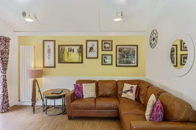 a living room with a brown leather couch at Squirrel Lodge 43 with Hot Tub in Newton Stewart