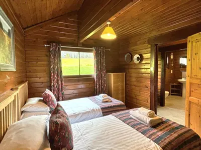 a bedroom with two beds in a log cabin at Lady Galloway 28 with Hot Tub in Newton Stewart