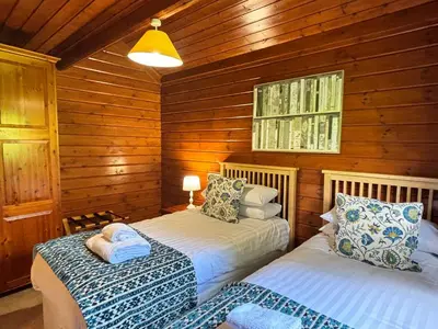 a bedroom with two beds in a wooden cabin at Lady Galloway 30 with Hot Tub in Newton Stewart