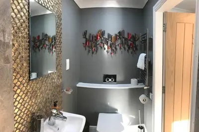 a bathroom with a sink and a toilet and a mirror at Amazing Cottage & detached Annex sleeps 8, Extra Deep Hot tub, Super Fast wifi, New for 2024 is the addition of Wood Fired Sauna in Castle Douglas