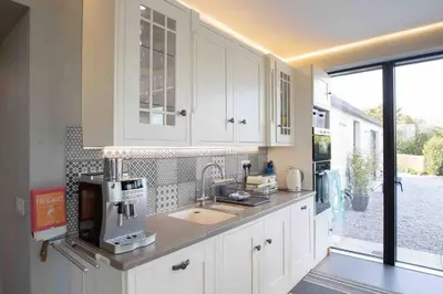 a kitchen with white cabinets and a coffee maker at Amazing Cottage & detached Annex sleeps 8, Extra Deep Hot tub, Super Fast wifi, New for 2024 is the addition of Wood Fired Sauna in Castle Douglas