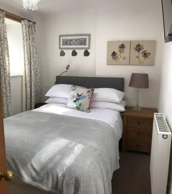a bedroom with a bed with white sheets and pillows at Abbey Green, New Abbey, Dumfries and Galloway in Dumfries