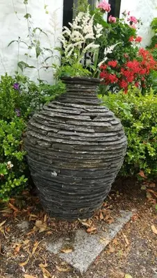 a large black vase with flowers in a garden at Abbey Green, New Abbey, Dumfries and Galloway in Dumfries