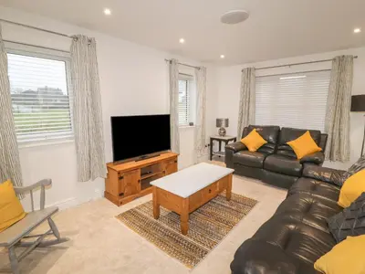 a living room with a couch and a flat screen tv at Beckside House in Cockermouth