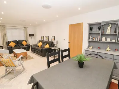 a kitchen and living room with a table and chairs at Beckside House in Cockermouth
