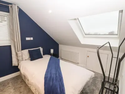 a bedroom with a bed with a blue wall at Beckside House in Cockermouth