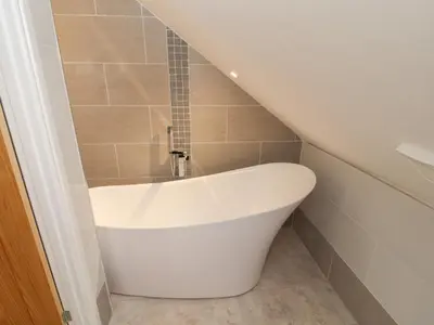 a white bath tub in a bathroom with a stair at Beckside House in Cockermouth