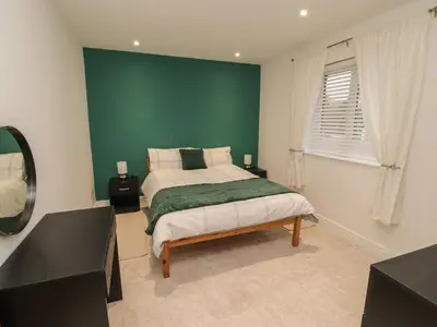 a bedroom with a green wall and a bed at Beckside House in Cockermouth