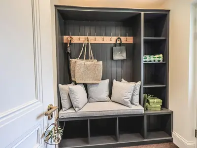 a bench in a book shelf with pillows at Whisk Away Cottage in Penrith