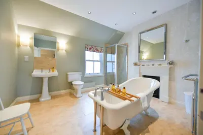 a bathroom with a tub and a sink and a toilet at High Clachan Farmhouse in Stranraer