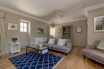 a living room with a couch and a table at Home Farm Cottage in Stranraer