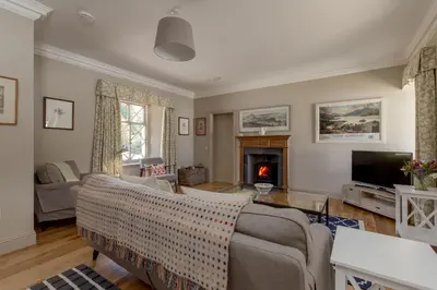 a living room with a couch and a tv at Home Farm Cottage in Stranraer
