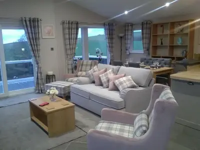 a living room with a couch and chairs and a table at Turnberry lodge in Girvan