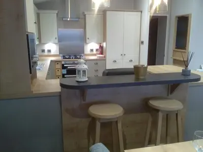 a kitchen with a counter and stools in it at Turnberry lodge in Girvan